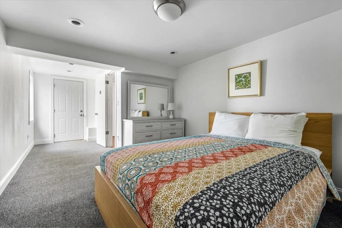 Bedroom with Colorful Patchwork Quilt & Gray Dresser