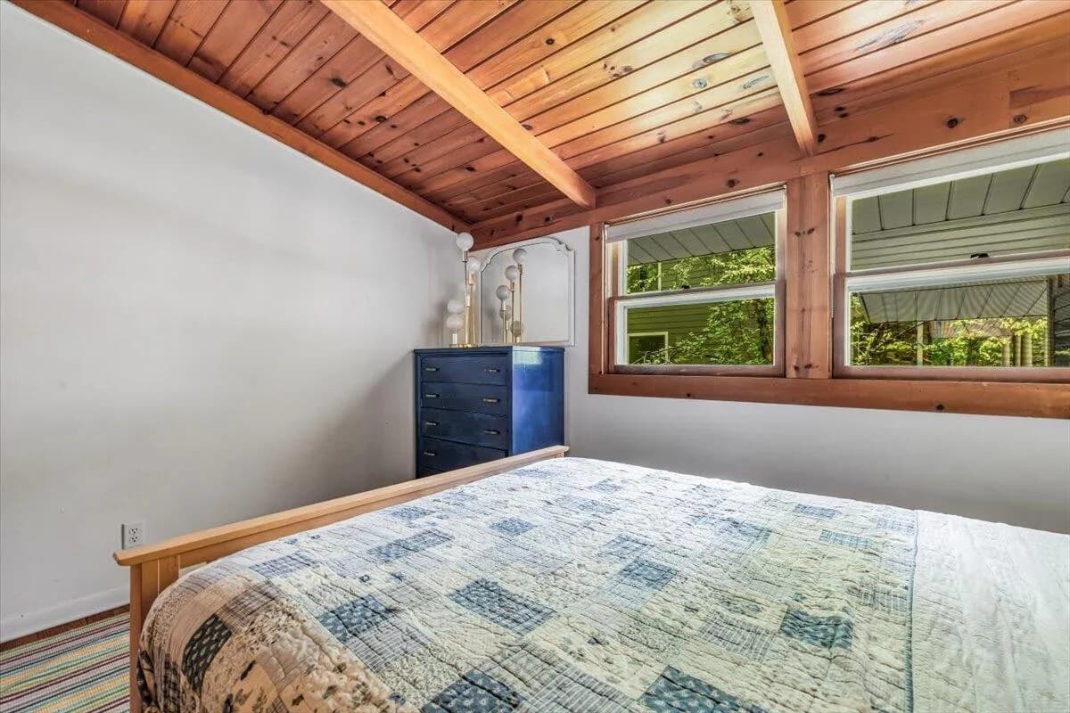 Cozy Bedroom with Sloped Wood Ceiling & Blue Dresser